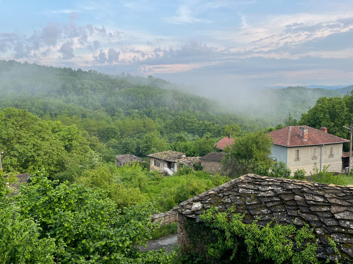 Зелени склонове и къщи в Старилковци, покрити с мъгла