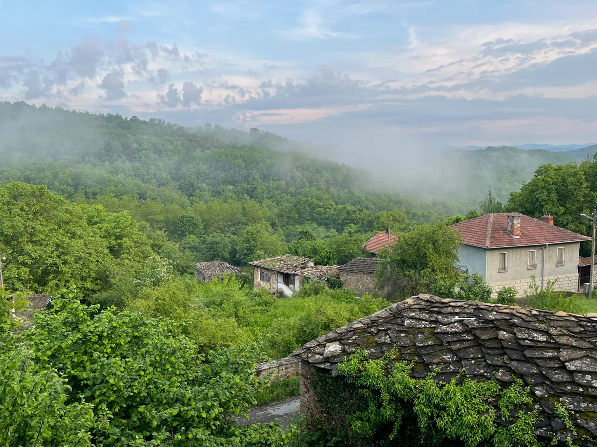 Зелени склонове и къщи в Старилковци, покрити с мъгла
